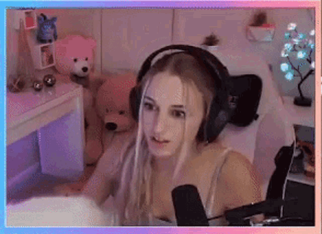 a woman wearing headphones is sitting on a bed in front of a microphone .