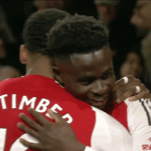 a man in a red shirt with the name timber on the back is hugging another man