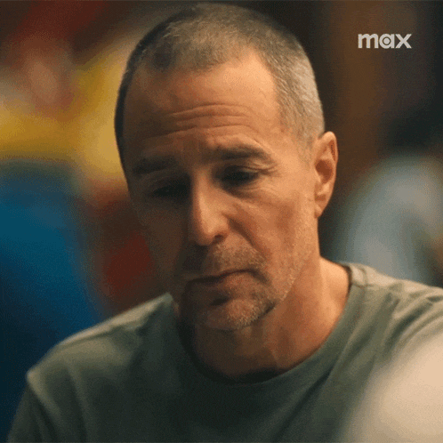 a close up of a man 's face with a max logo behind him