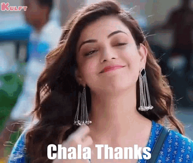 a woman wearing earrings and a blue shirt is smiling and says ' chala thanks ' on the screen .