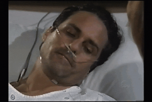 a man is laying in a hospital bed with an oxygen mask on