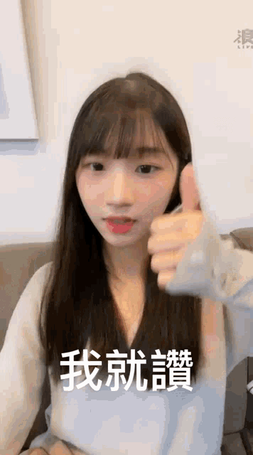 a girl with long hair is giving a thumbs up in chinese