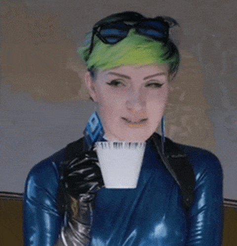 a woman in a blue latex outfit is holding a cup of coffee