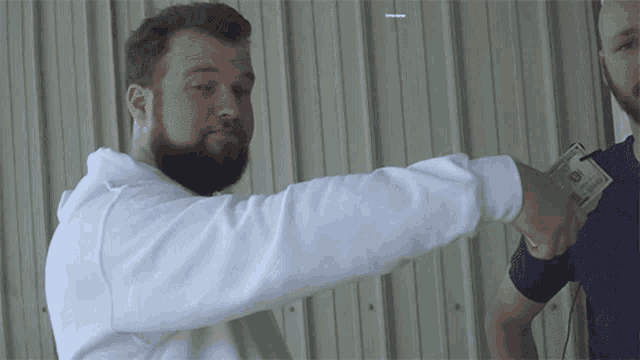 a man with a beard is holding a twenty dollar bill in his hand