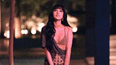 a woman in a very revealing dress stands in front of a tree