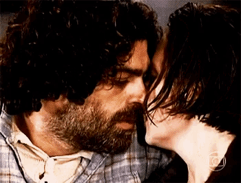 a man with a beard and a woman with long hair kissing each other