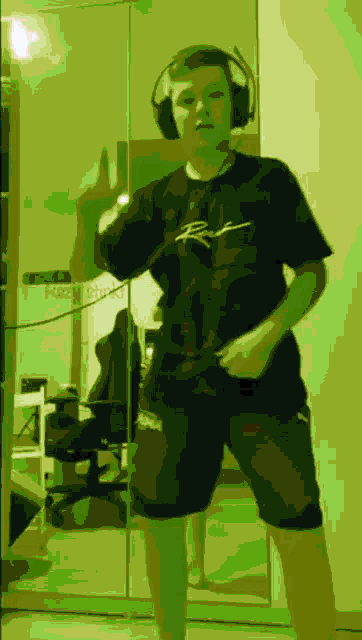 a person wearing headphones and a shirt with the letter r on it is dancing in front of a mirror