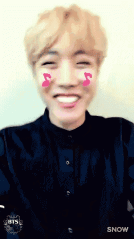 a young man with pink hearts on his cheeks and the word snow behind him
