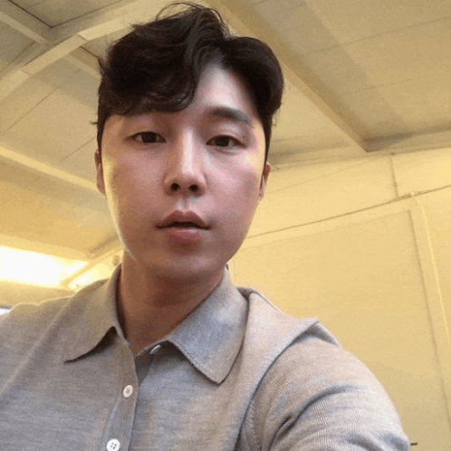 a man taking a selfie with a gray shirt on