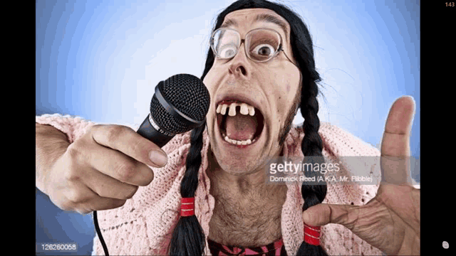 a woman with pigtails and glasses singing into a microphone