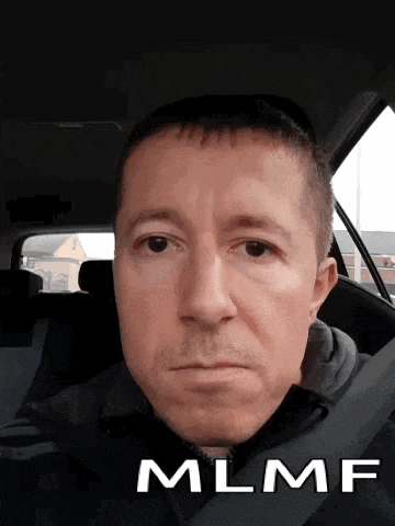 a man sitting in a car with the word mlnf on the bottom right
