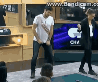 a man in a white shirt is dancing in front of a screen that says cha