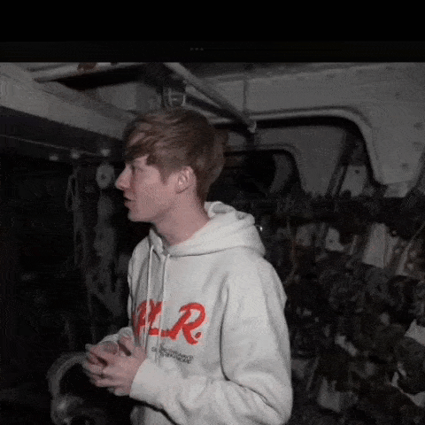 a young man wearing a white hoodie with a red r on it