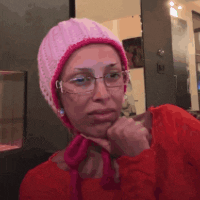 a woman wearing glasses and a pink beanie