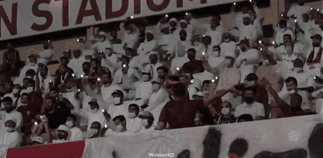 a crowd of people in a stadium with a sign that says ns stadium