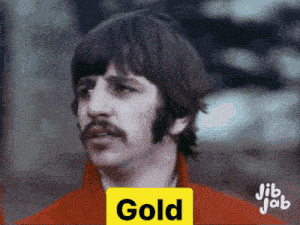 a man in a red jacket has a yellow sign that says gold