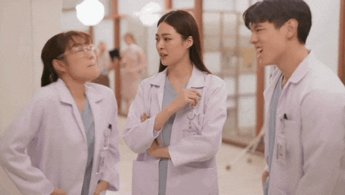 a man kisses a woman on the cheek while two other doctors look on
