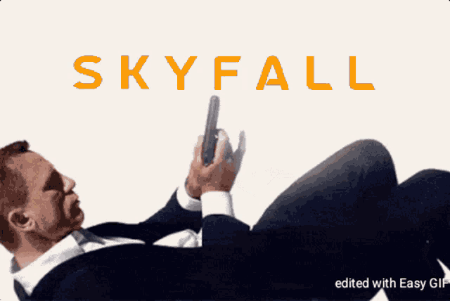 a man is laying on the floor holding a gun and the word skyfall is on the bottom