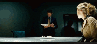 a man and a woman are sitting at a table with a plate of food on the table