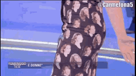 a woman wearing a skirt with a pattern of women 's faces is on a screen that says pomeriggio e donne