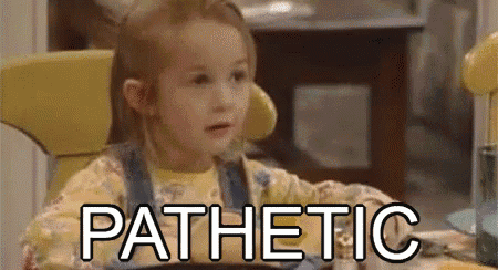 a little girl is sitting at a table with a bowl of cereal and the word pathetic .