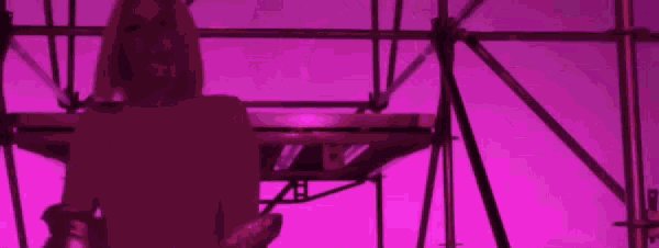 a person is standing in front of a purple scaffolding