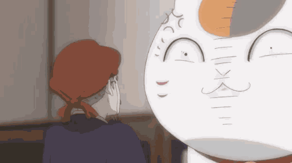 a man and a cat are looking at each other in a room .