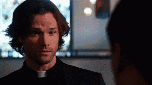 a priest is talking to another man in a church .
