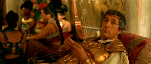 a man in a gold costume sits in a chair