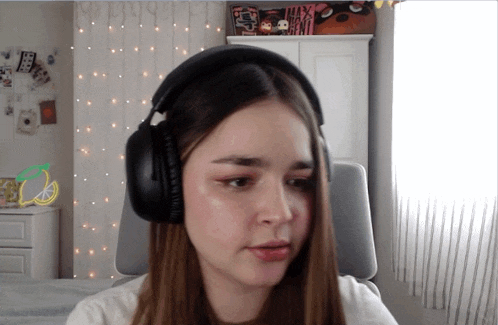 a girl wearing headphones in a room with a sign that says ' max ' on it