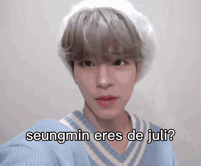 a young man wearing a blue sweater and a white hat says seungmin eres de juli ?