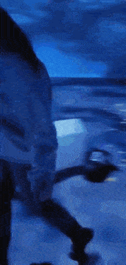 a person is standing in a dark room with a blue background