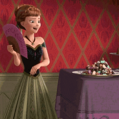 a woman in a green dress is holding a fan in front of a plate of candy
