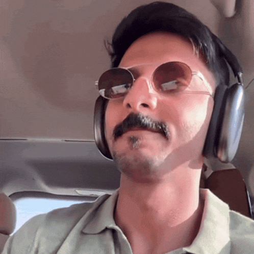 a man wearing sunglasses and headphones looks to his left