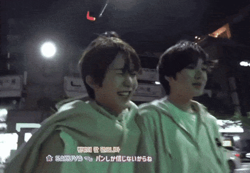 a couple of people standing next to each other with the word sakuya in the corner