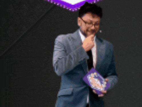a man in a suit and tie is holding a book