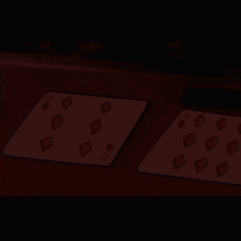two playing cards on a table one of which has the number six on it
