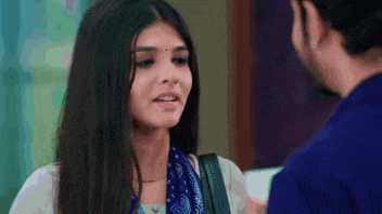 a man and a woman are looking at each other and the woman is wearing a blue scarf
