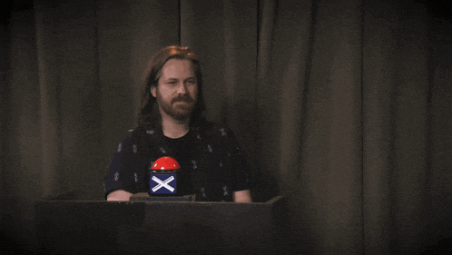 a man behind a podium with a button that says " oh "