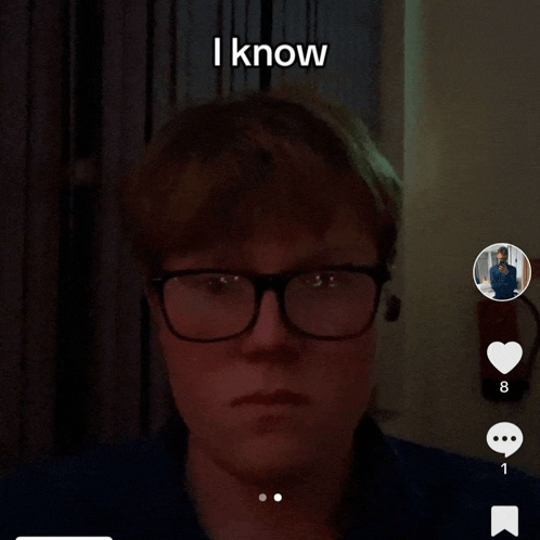 a man wearing glasses says " i know " in the corner of his face