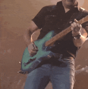 a man in a cowboy hat is playing an electric guitar