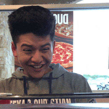 a young man wearing a grey sweatshirt with the word evian on it smiles