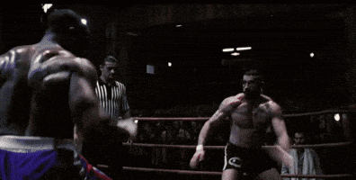 a referee in a boxing ring watches two boxers fight