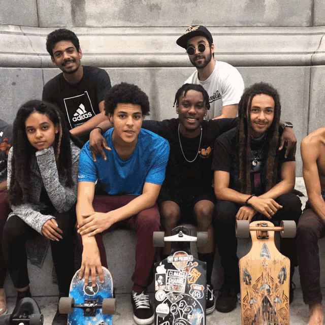 a group of young people are posing for a picture and one of them is wearing a blue adidas shirt