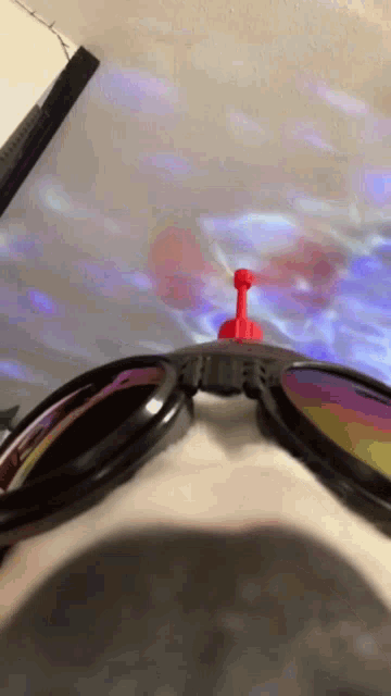 a pair of sunglasses with a red antenna on top