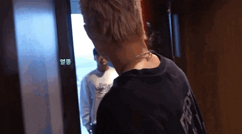 a man in a black shirt is standing next to another man in a white shirt in a hallway .