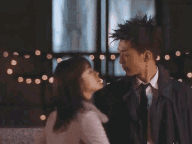 a man in a suit and tie kisses a woman