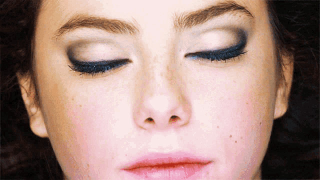 a close up of a woman 's face with closed eyes