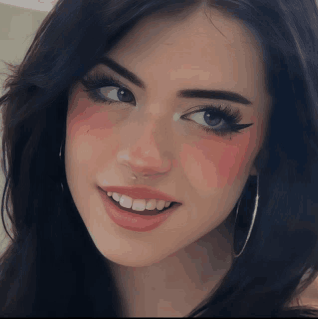 a close up of a woman 's face with a nose ring