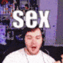 a man is sitting on a couch with the word sex on his head
